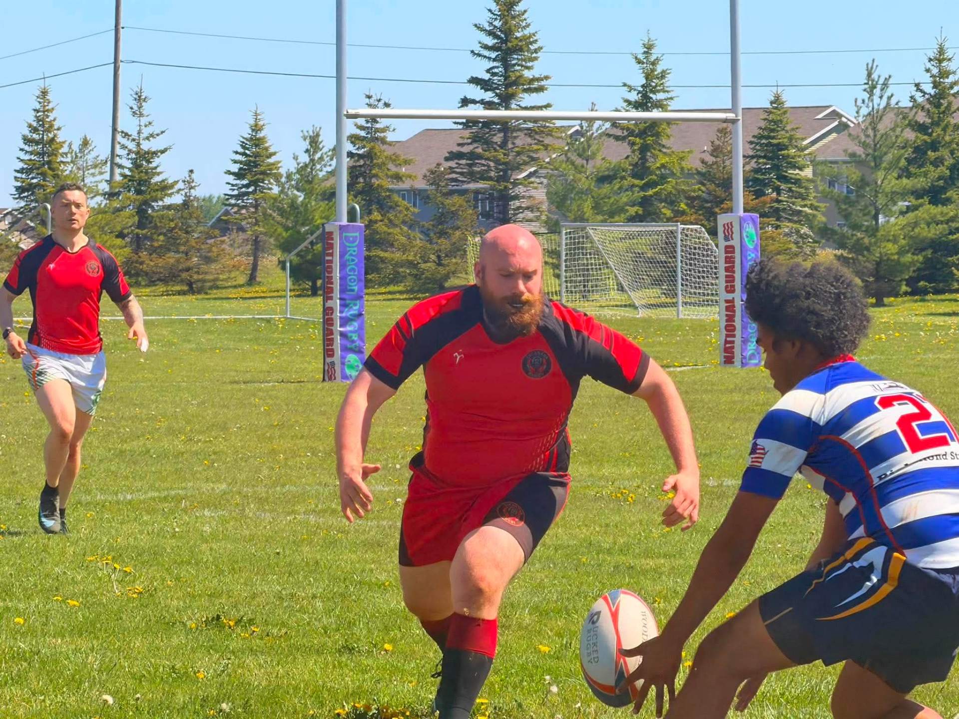 Berserkers player carrying the ball toward the posts against a defender
