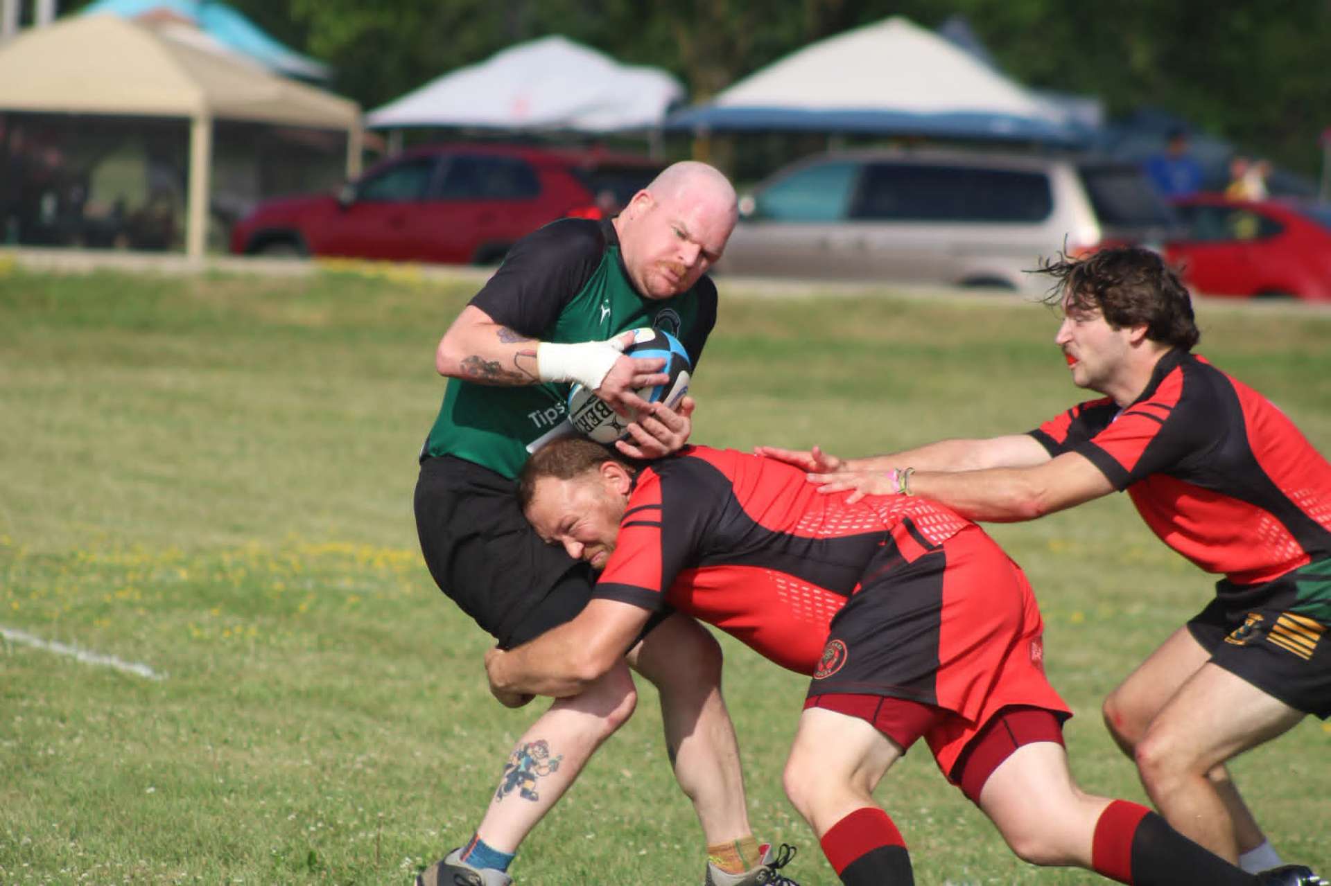 Berserkers defender wrapping up a green-jersey ball carrier as a teammate arrives
