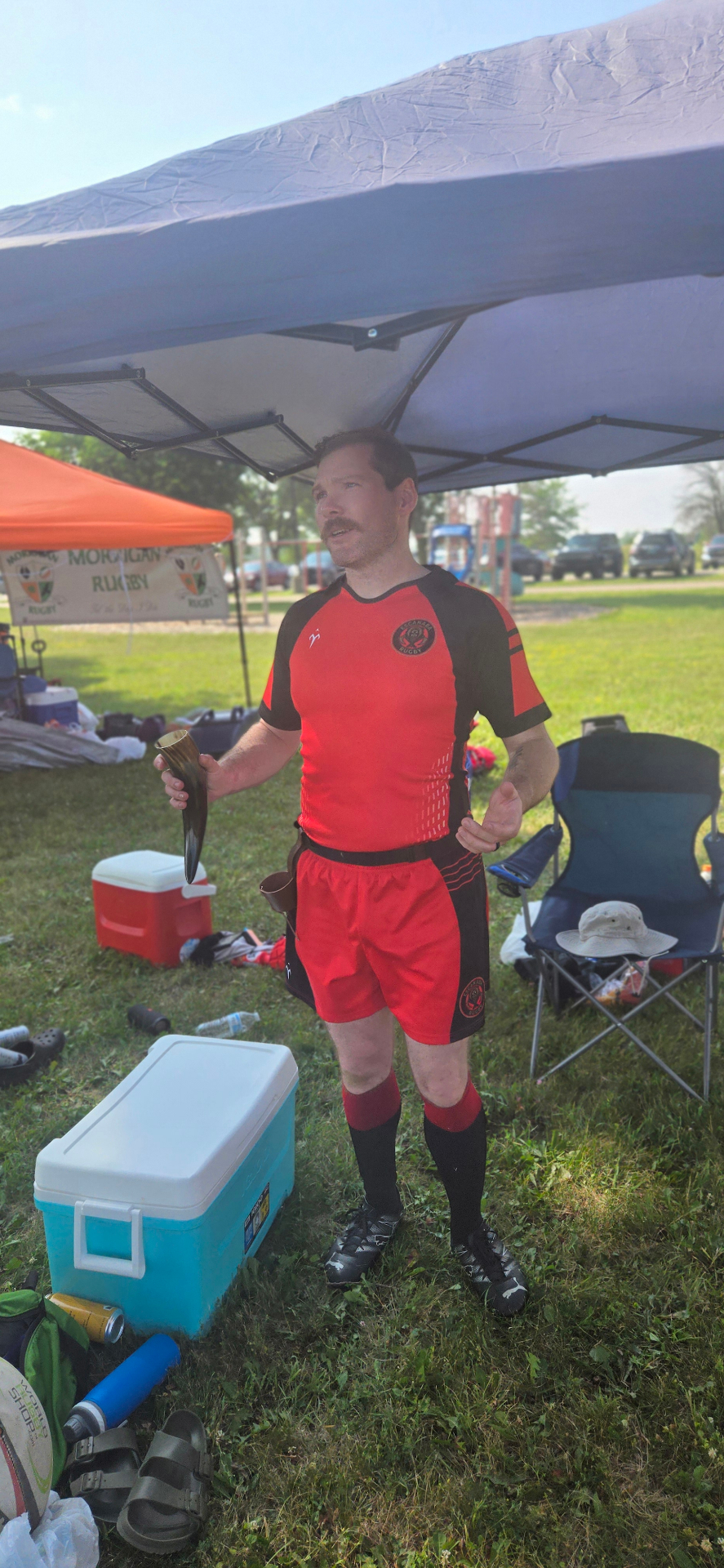 Berserkers player holding a drinking horn at the club tent on match day
