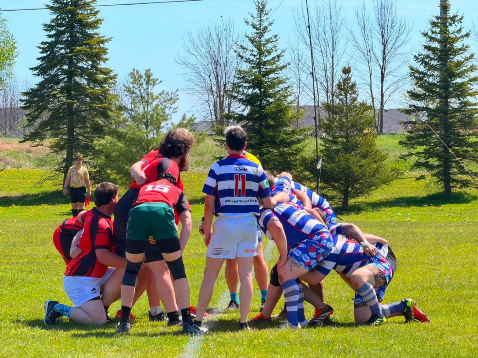 Berserkers pack setting a scrum against a blue and white striped club